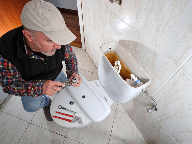plombier répare chasse eau