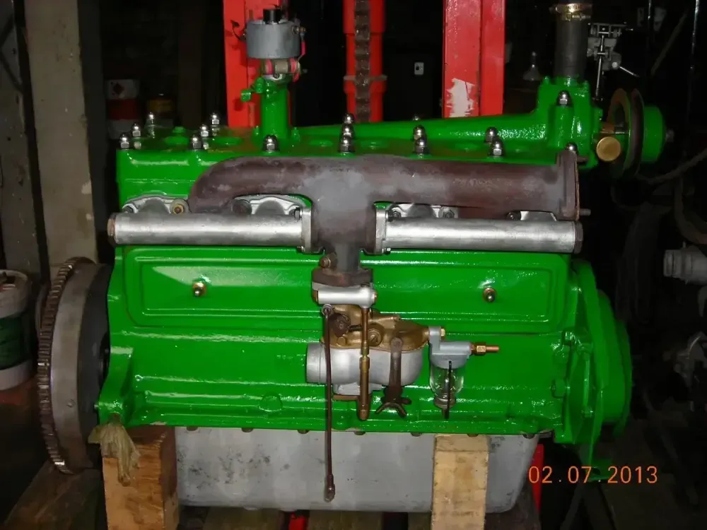 Un moteur industriel ou un groupe électrogène vert vif, avec des tuyauteries métalliques, dans une salle des machines sombre