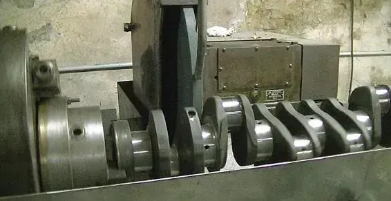 Machine industrielle avec des arbres métalliques rotatifs et des engrenages dans un atelier