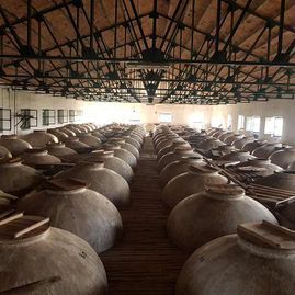 Un gran almacén lleno de muchas vasijas de barro.