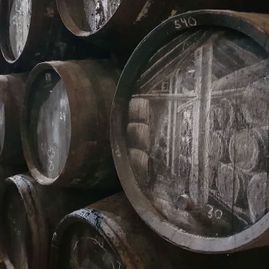 Un montón de barriles están apilados uno encima del otro en un almacén.