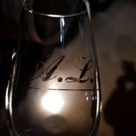 Una copa de vino con las iniciales a y l.