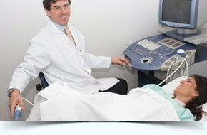 Un médico está examinando a una mujer embarazada con una máquina de ultrasonido.