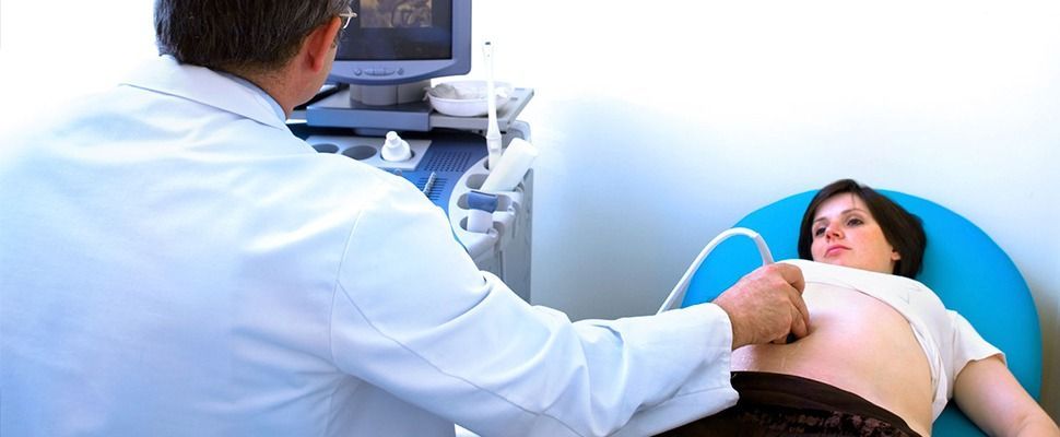 Una mujer embarazada se está haciendo una ecografía con un médico.