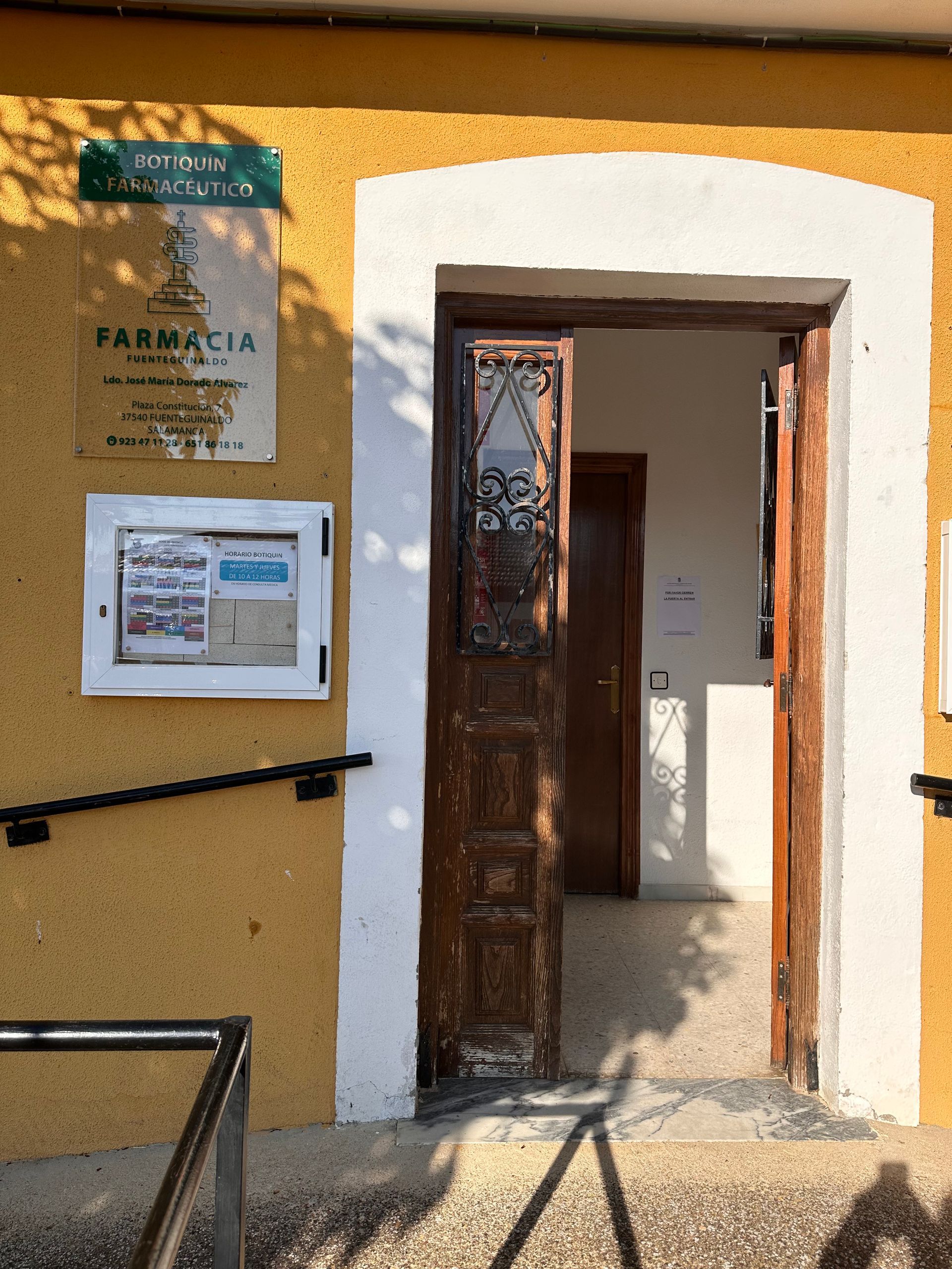 Un edificio amarillo con un cartel que dice farmacia.
