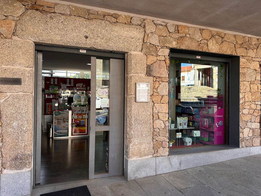 Un frente de tienda con una puerta corrediza de vidrio y una pared de piedra.
