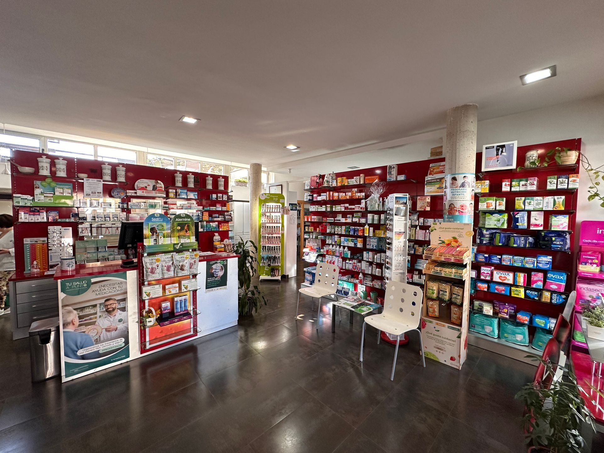 El interior de una farmacia con muchos estantes y un mostrador.