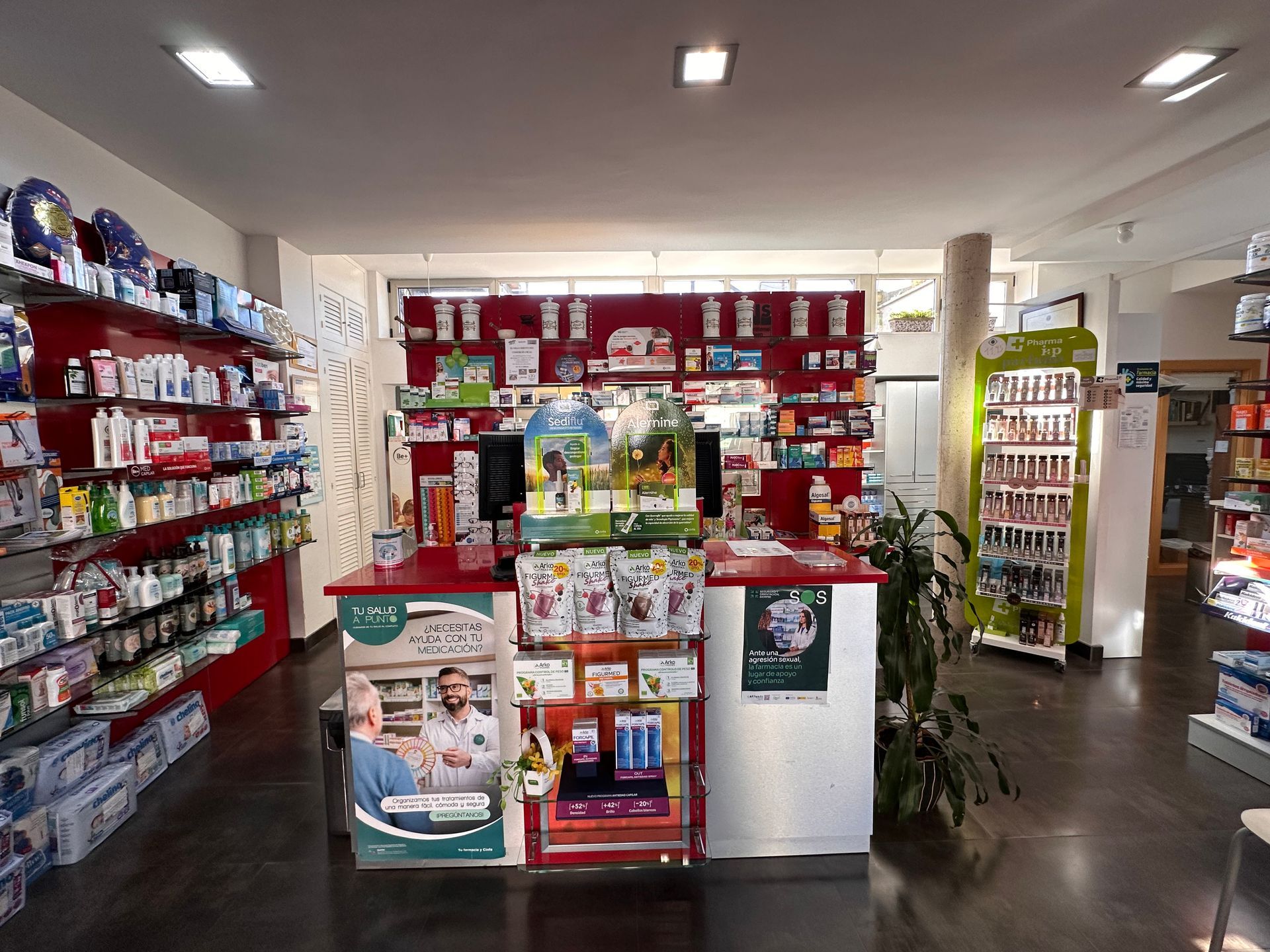 El interior de una farmacia con muchos estantes y un mostrador.