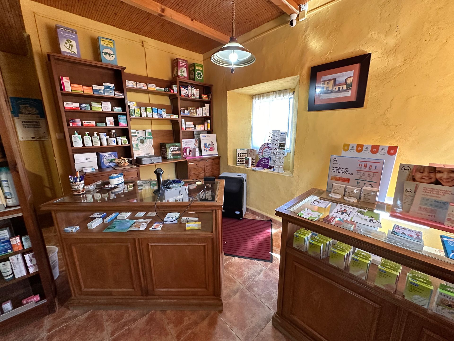 Una farmacia con mostrador, estantes y ventana.