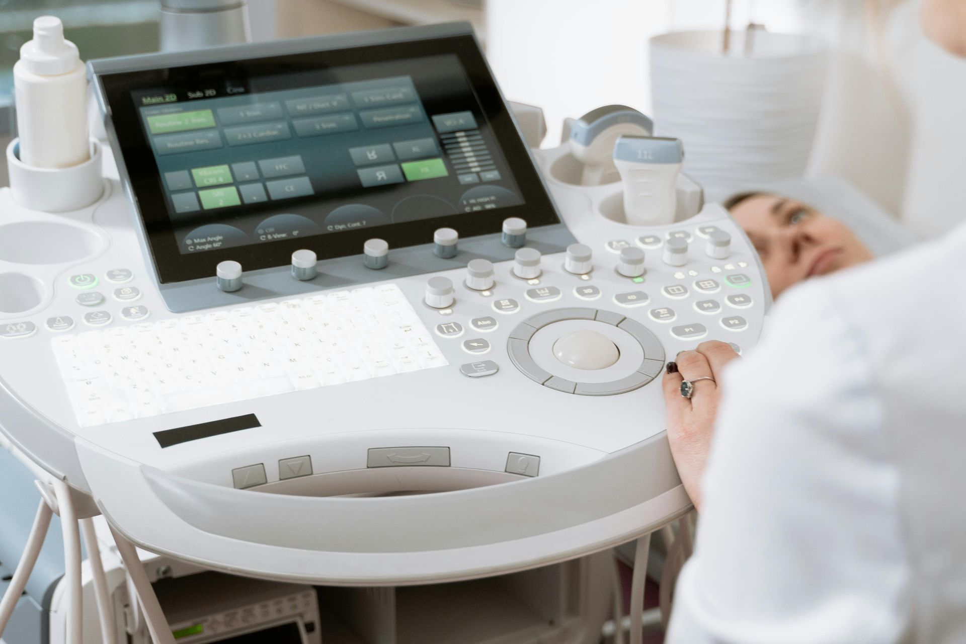 Ein medizinischer Fachmann bedient ein Ultraschallgerät bei der Untersuchung eines Patienten in einer klinischen Umgebung.