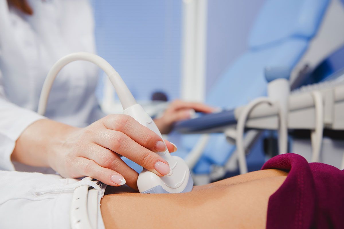 Eine medizinische Fachkraft führt eine Ultraschalluntersuchung des Abdomens bei einem Patienten durch.