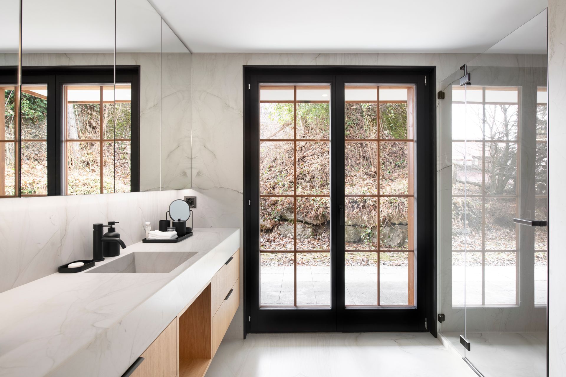 Vue d'une salle de bain avec un lavabo et une grande porte fenêtre