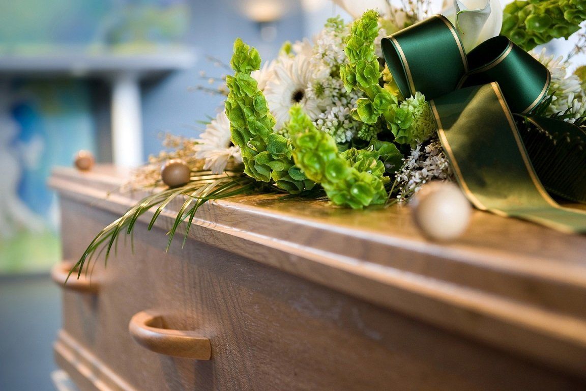 Cercueil en bois avec composition florale dessus