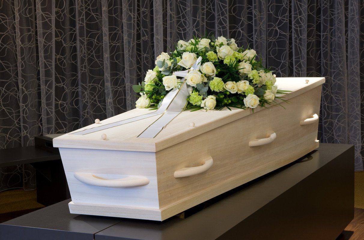 Fleurs blanches sur un cercueil blanc en bois