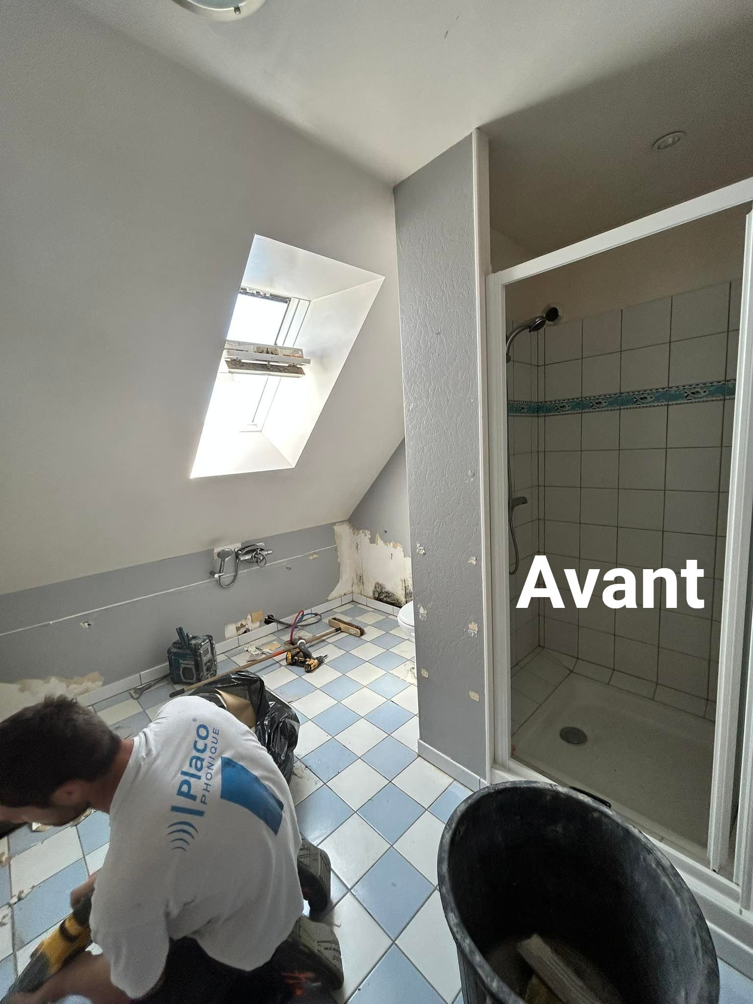 Pose de carrelage dans une salle de bains. Sol à motifs de losanges bleus et blancs. Cabine de douche.