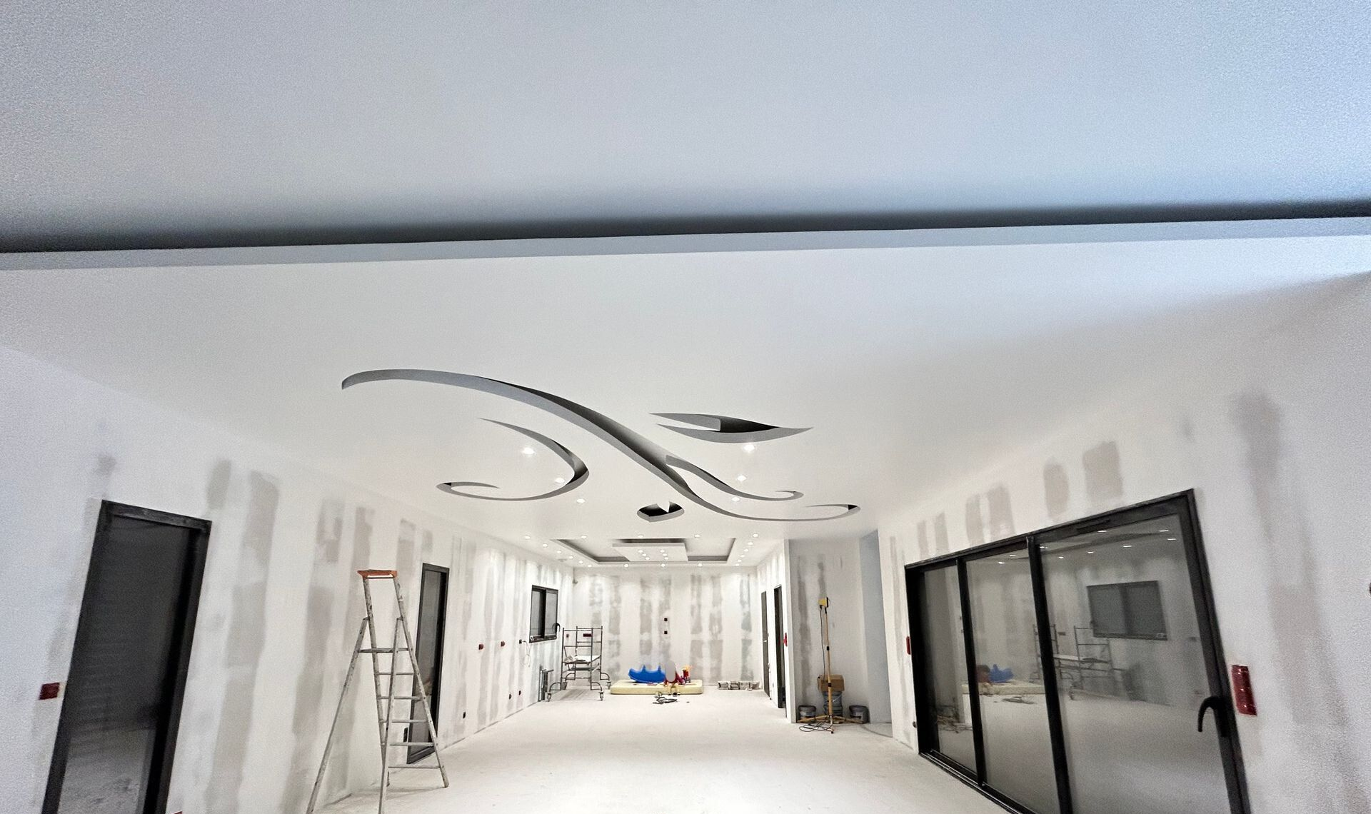 Une longue pièce en construction avec un plafond décoratif.