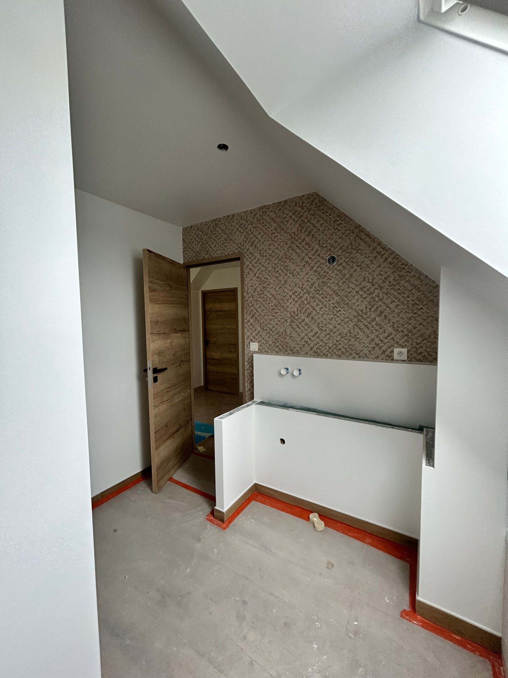 Création d'une salle de bains : enduit de finition et papier peint posés.