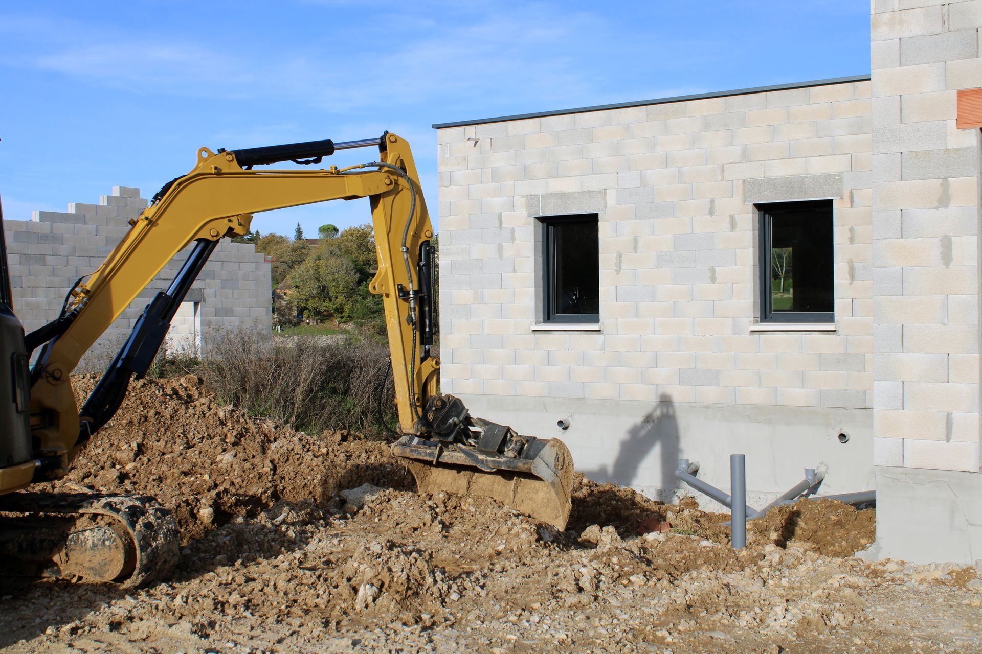 Minipelle devant une maison en construction 
