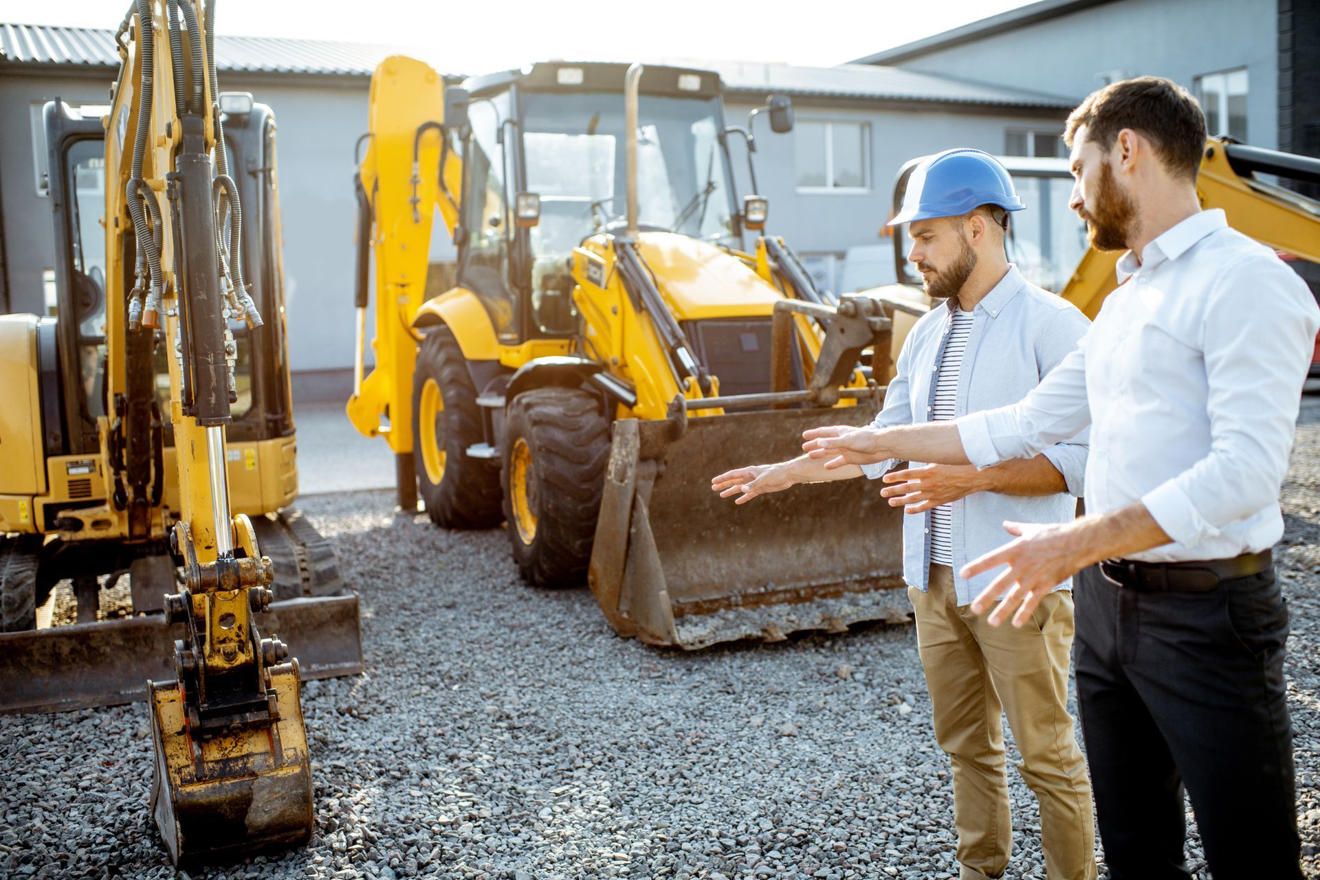 Constructeur choisissant des machines lourdes pour la construction avec un conseiller commercial sur le terrain