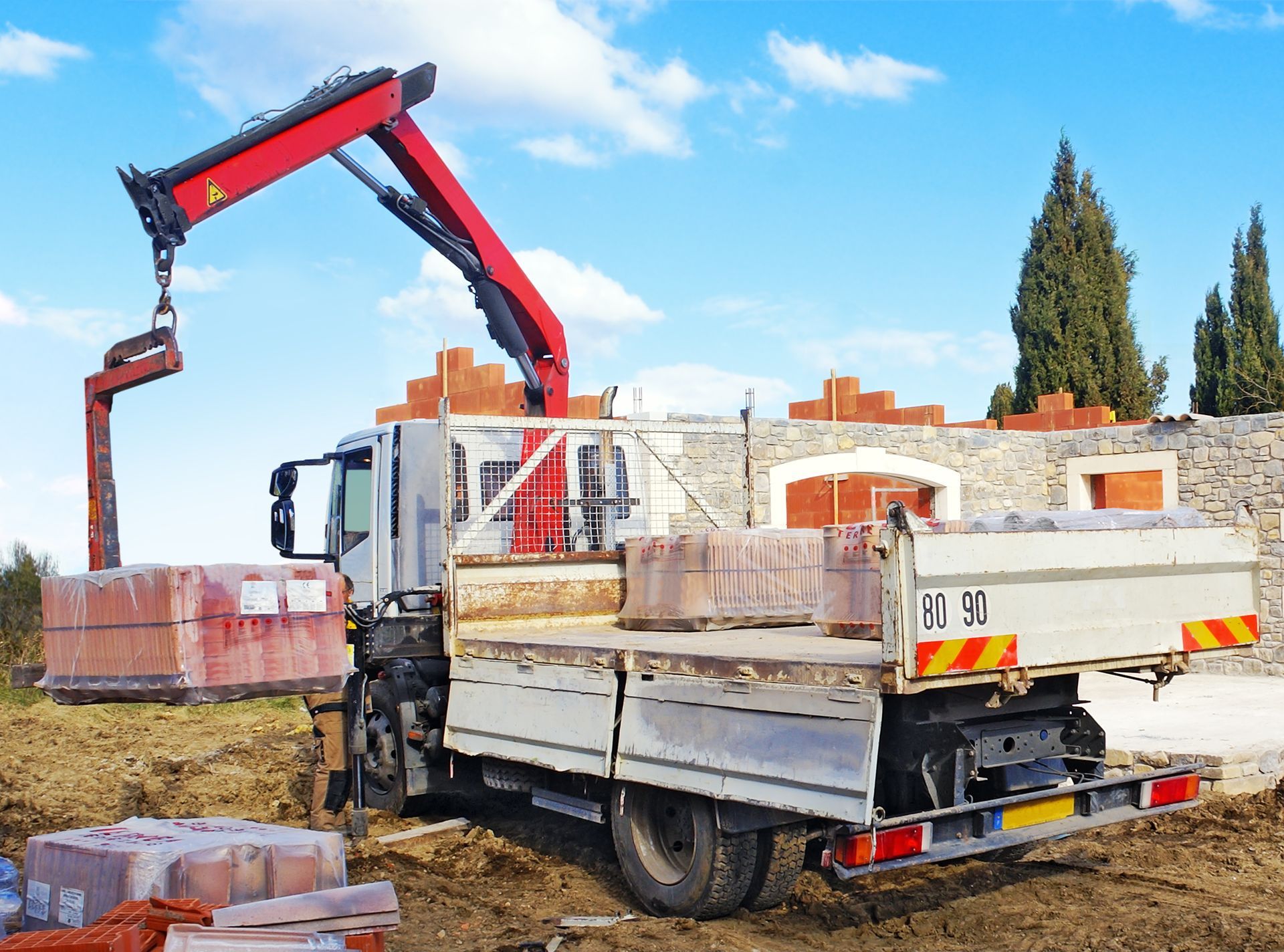 Camion-grue qui décharge des palettes de tuiles