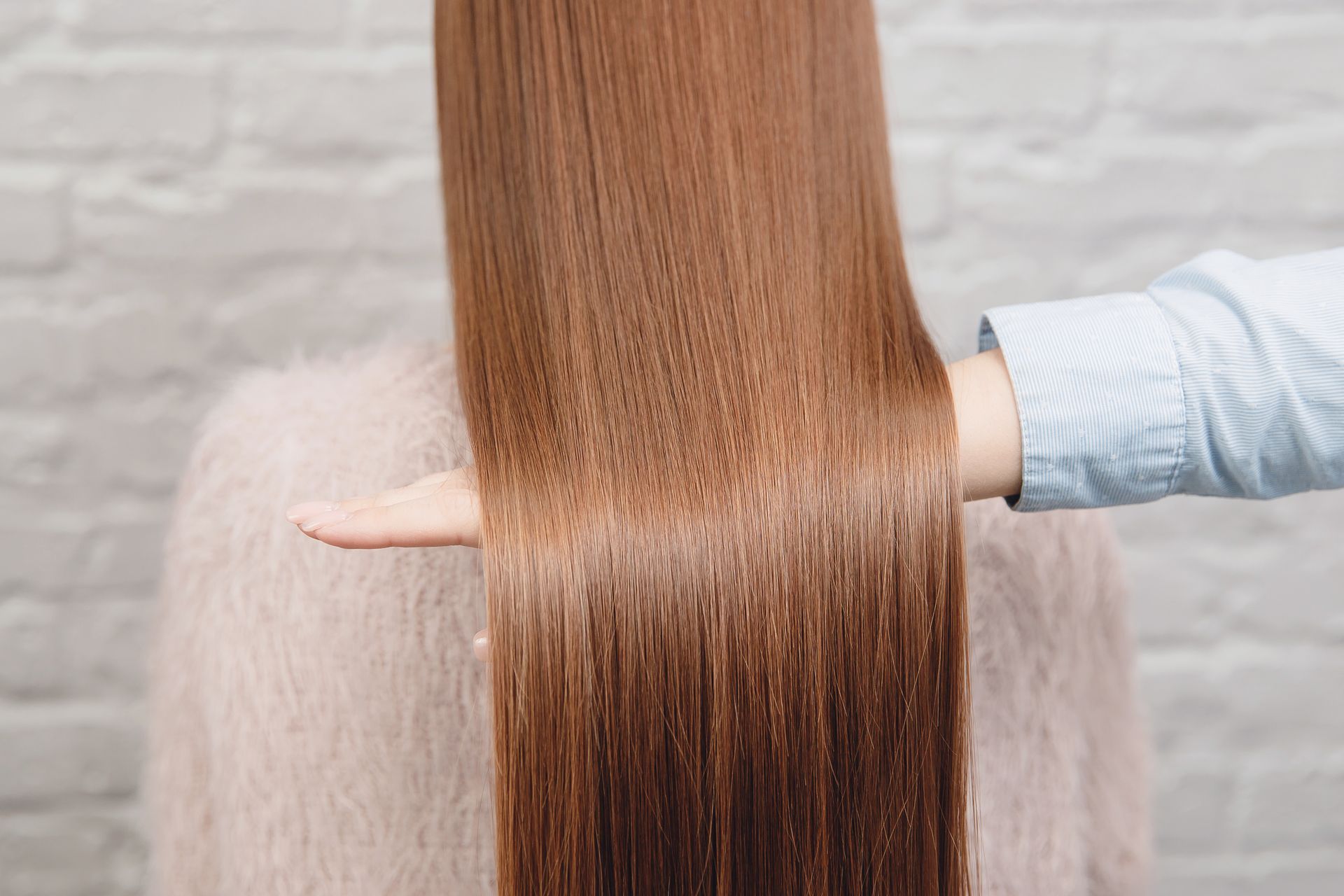 Eine Frau lässt sich von einem Friseur die Haare schneiden.