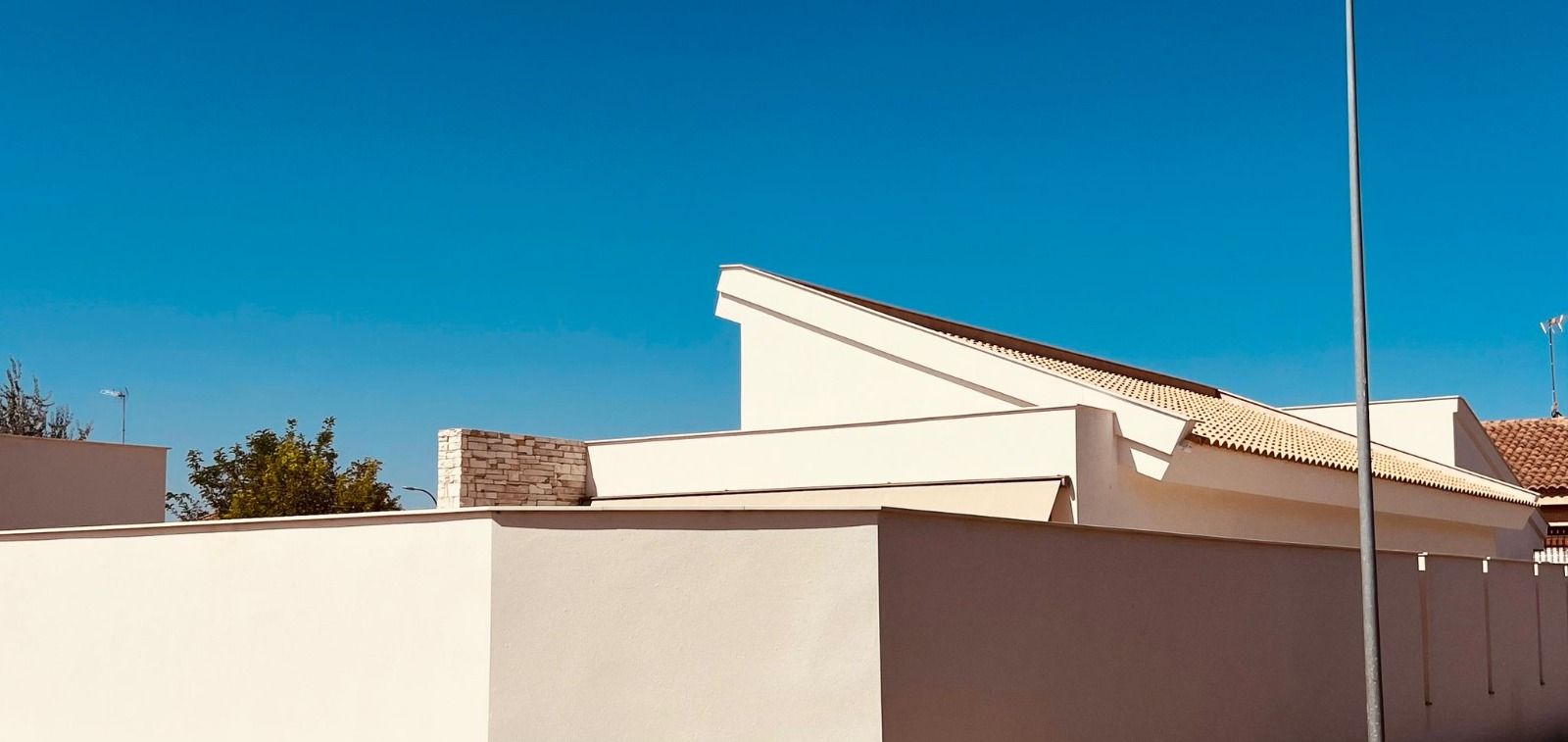 Edificio blanco contra un cielo azul brillante.