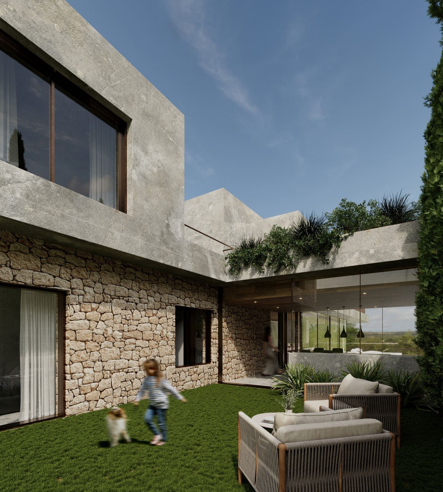 Niño y perro jugando en el césped verde en el patio de una casa moderna con paredes de piedra.