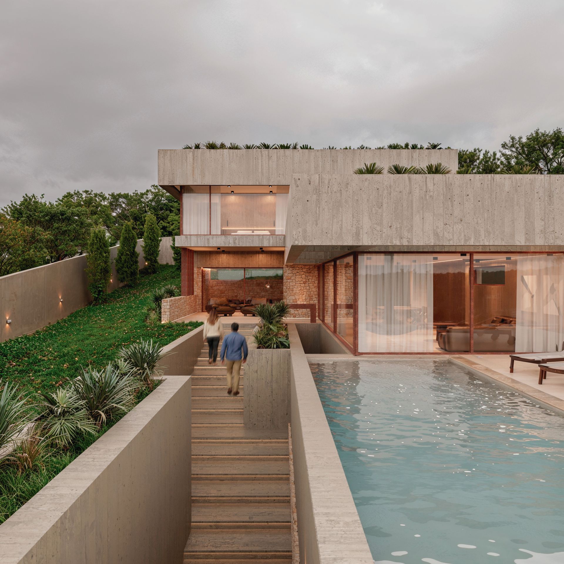 Casa moderna de concreto con piscina, escalones y dos personas caminando hacia la entrada.