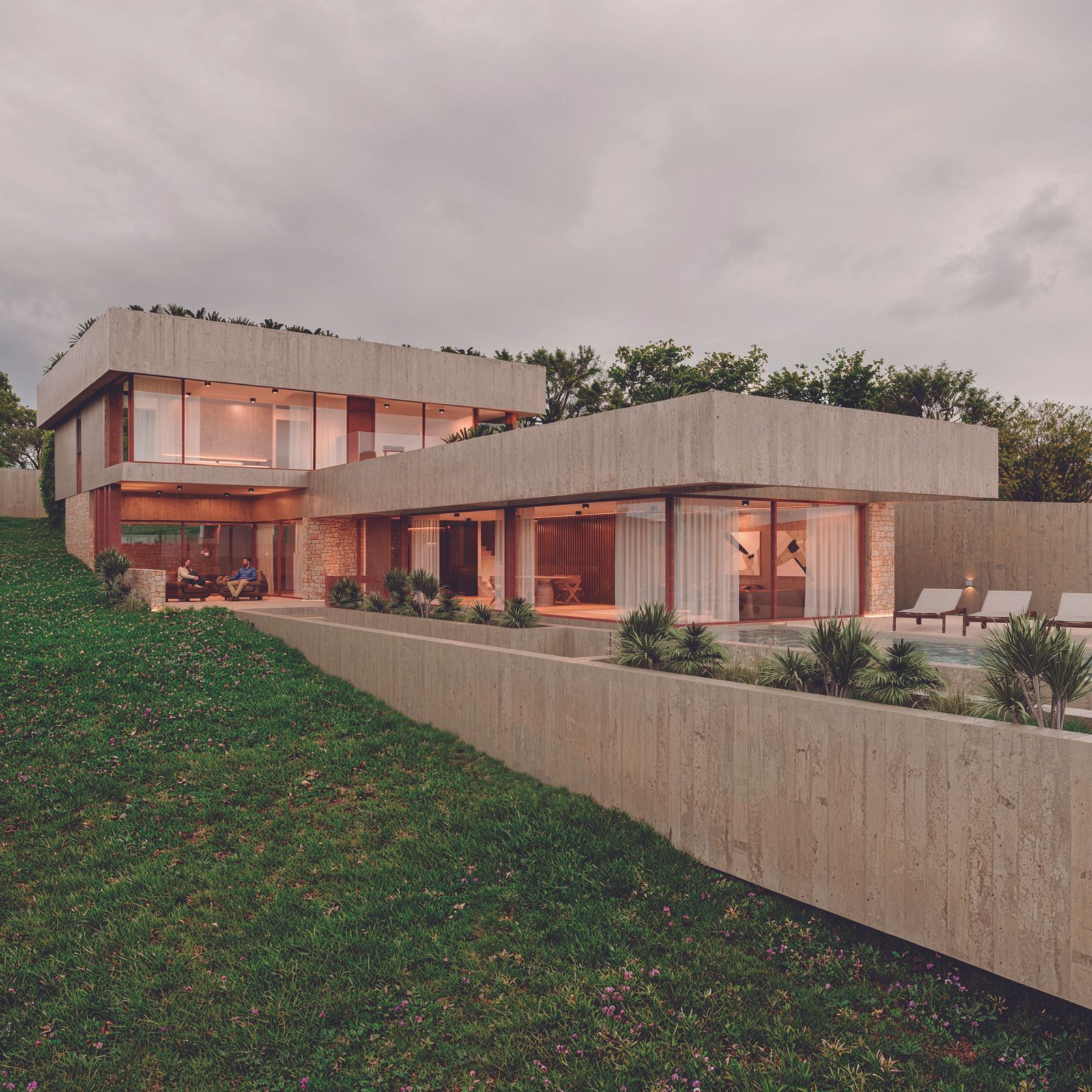 Moderna casa de hormigón de dos pisos con techo plano, detalles de madera y una pequeña piscina al lado en una colina cubierta de hierba.