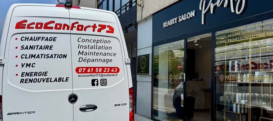 Camionnette blanche avec panneau « EcoConfort73 » à côté de la vitrine d'un salon de beauté.