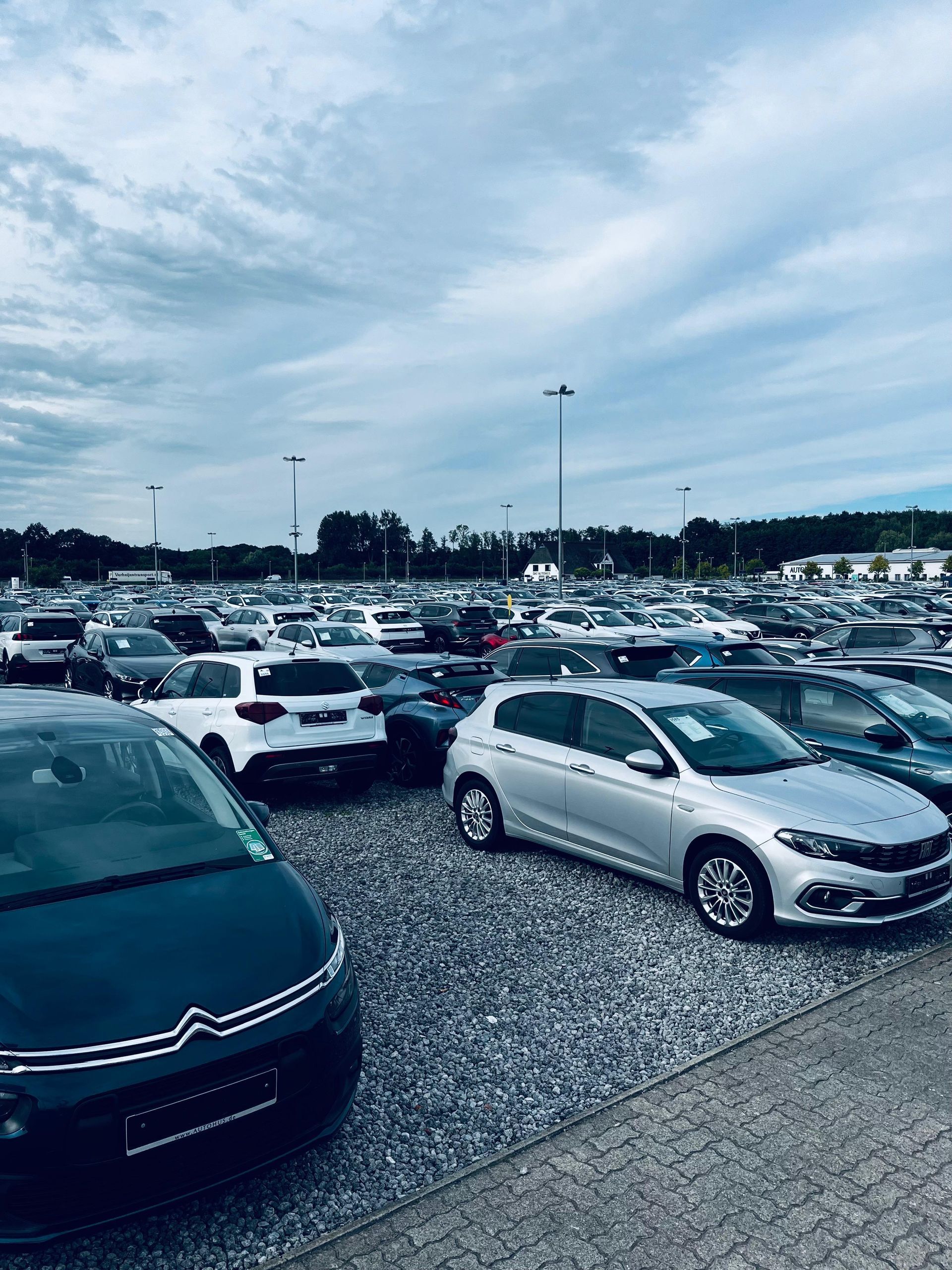 Persona entregando las llaves del coche a otra persona sobre un contrato en un escritorio de madera.