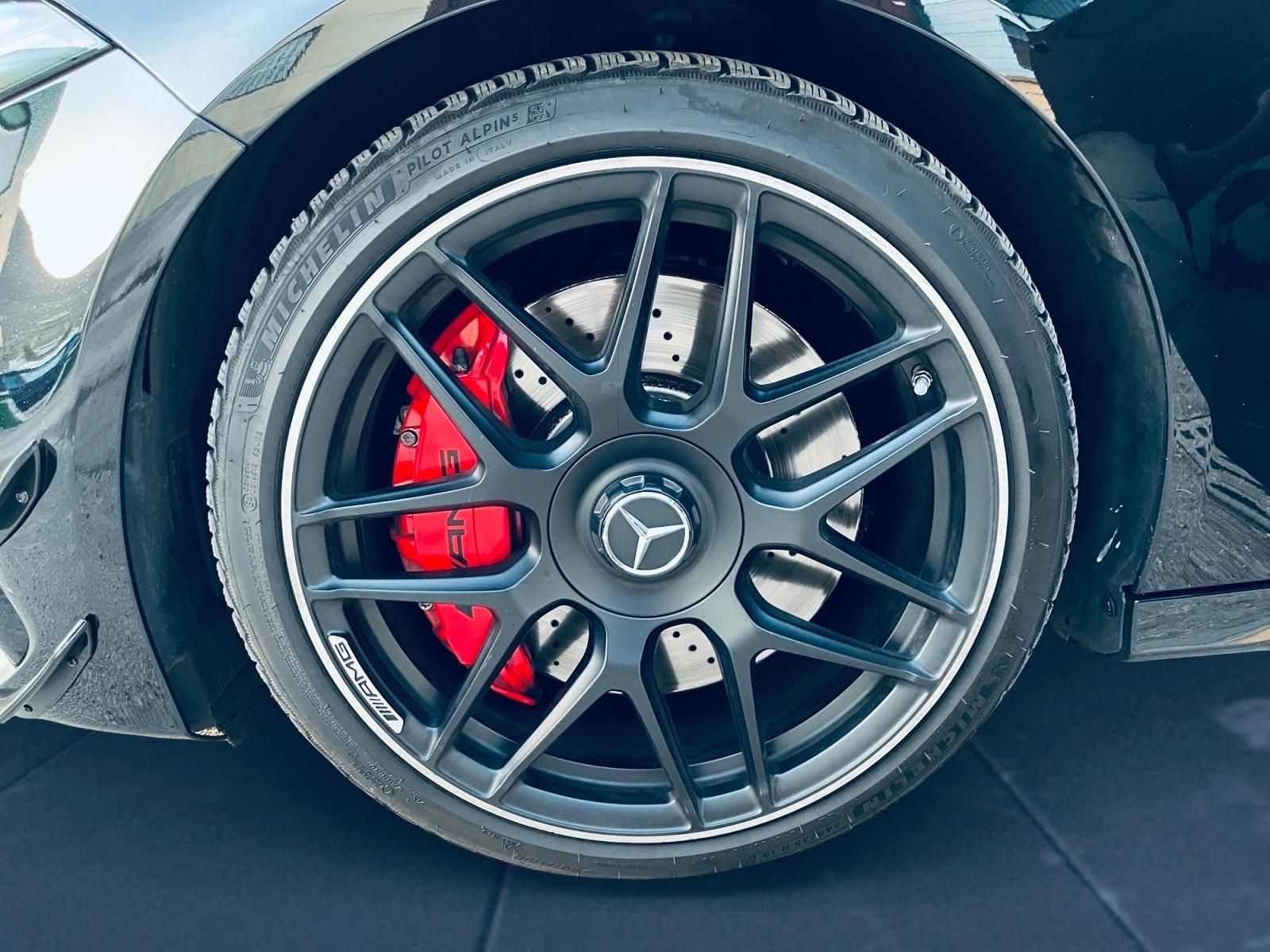 Dos mecánicos examinan el motor de un automóvil con una lista de verificación; uno señala la varilla de nivel.