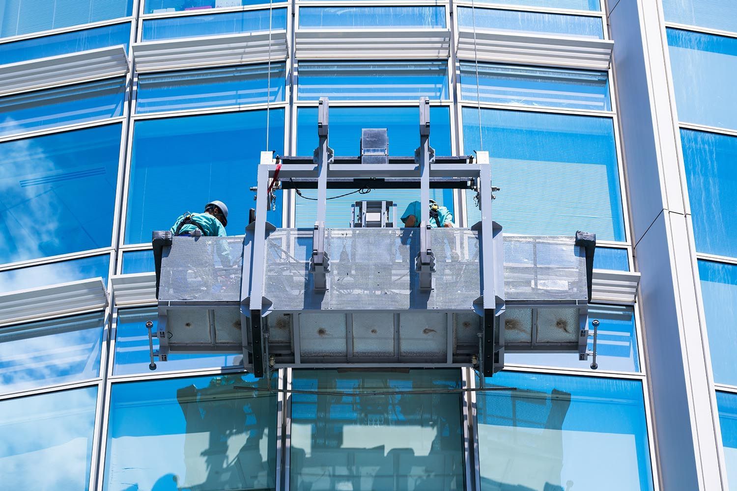 Façade vitrée immeuble entreprise en cours de nettoyage avec élévateur