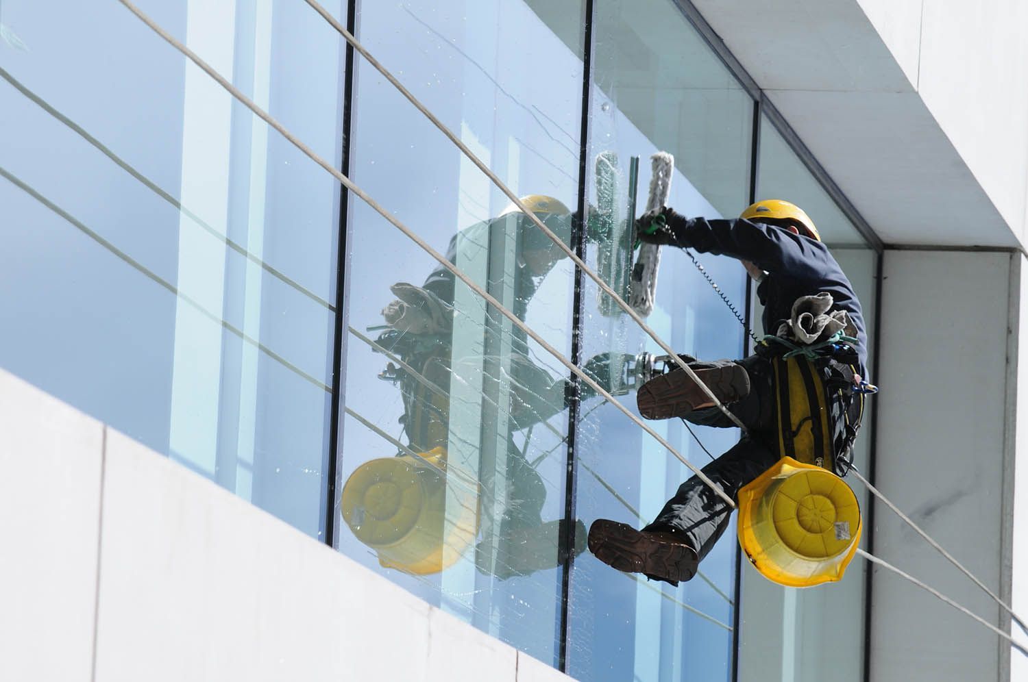 Un technicien en cours de nettoyage sur une façade en vitre