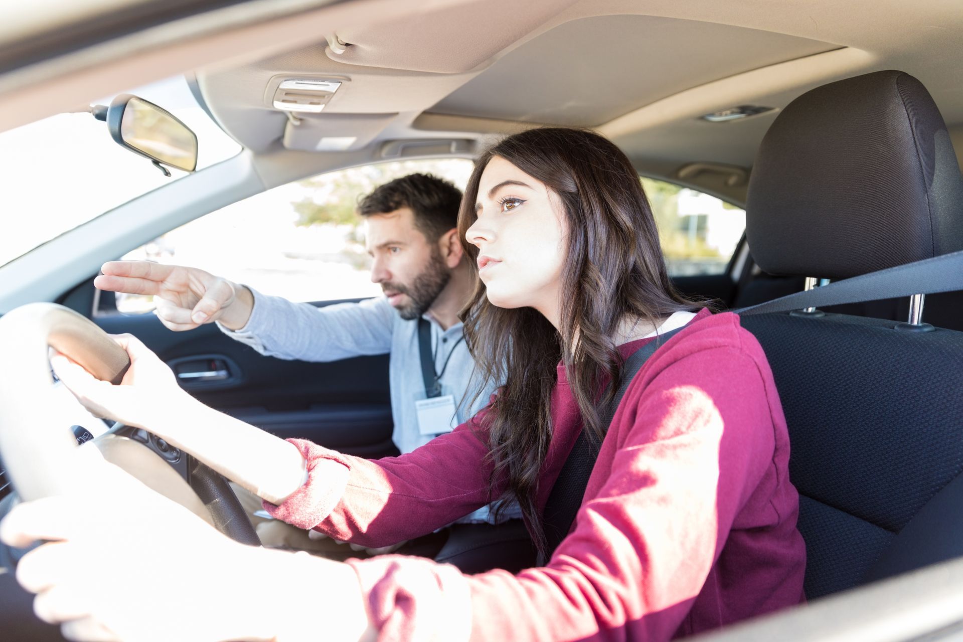 Une femme en train de perfectionner sa conduite avec une monitrice d'auto-école