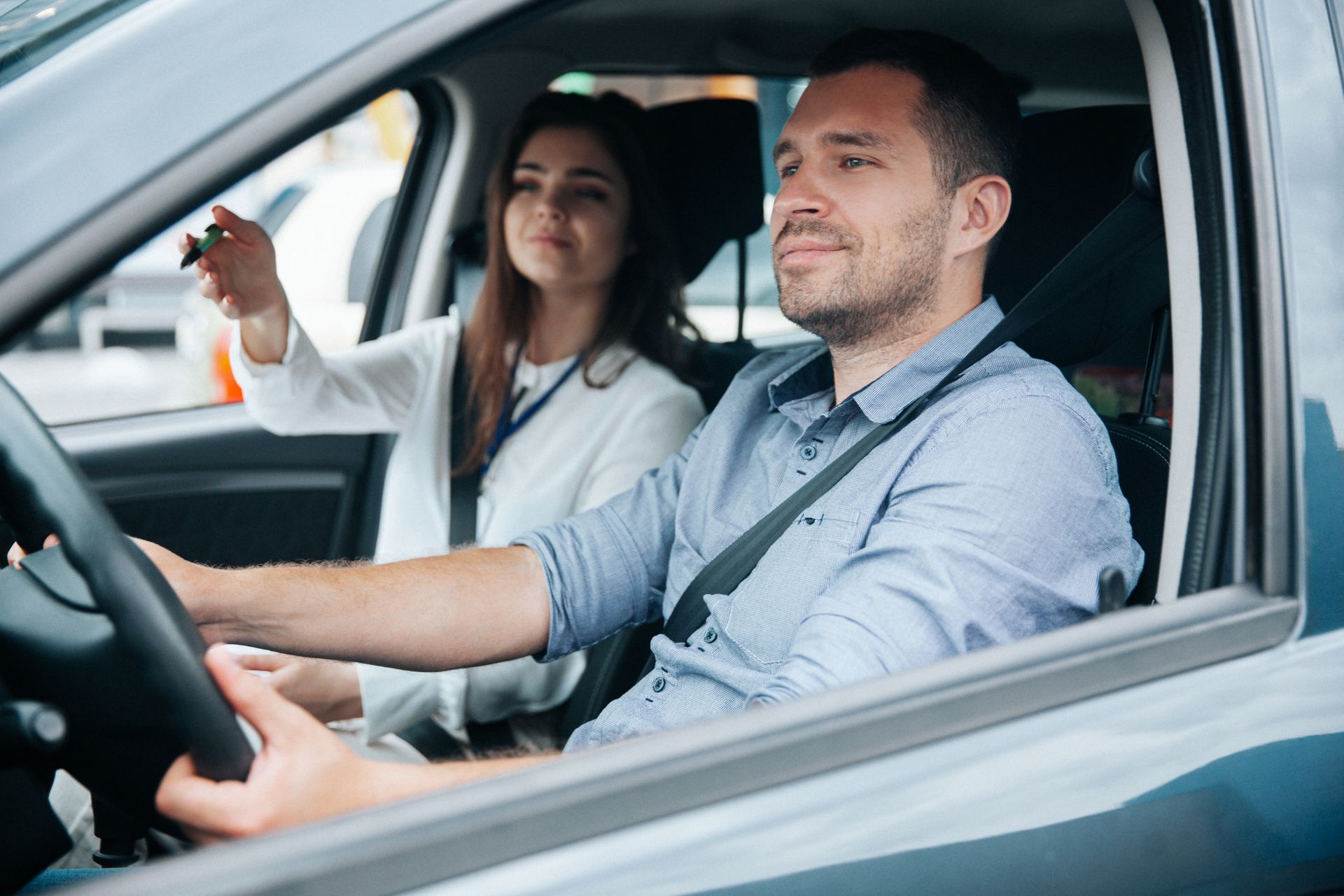 Un homme prenant un cours de conduite auprès d'une monitrice d'auto-école