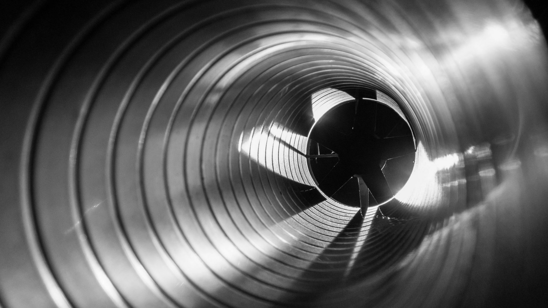 Trois ouvriers installent des unités de climatisation sur le toit d'un immeuble. Une grue soulève deux unités.