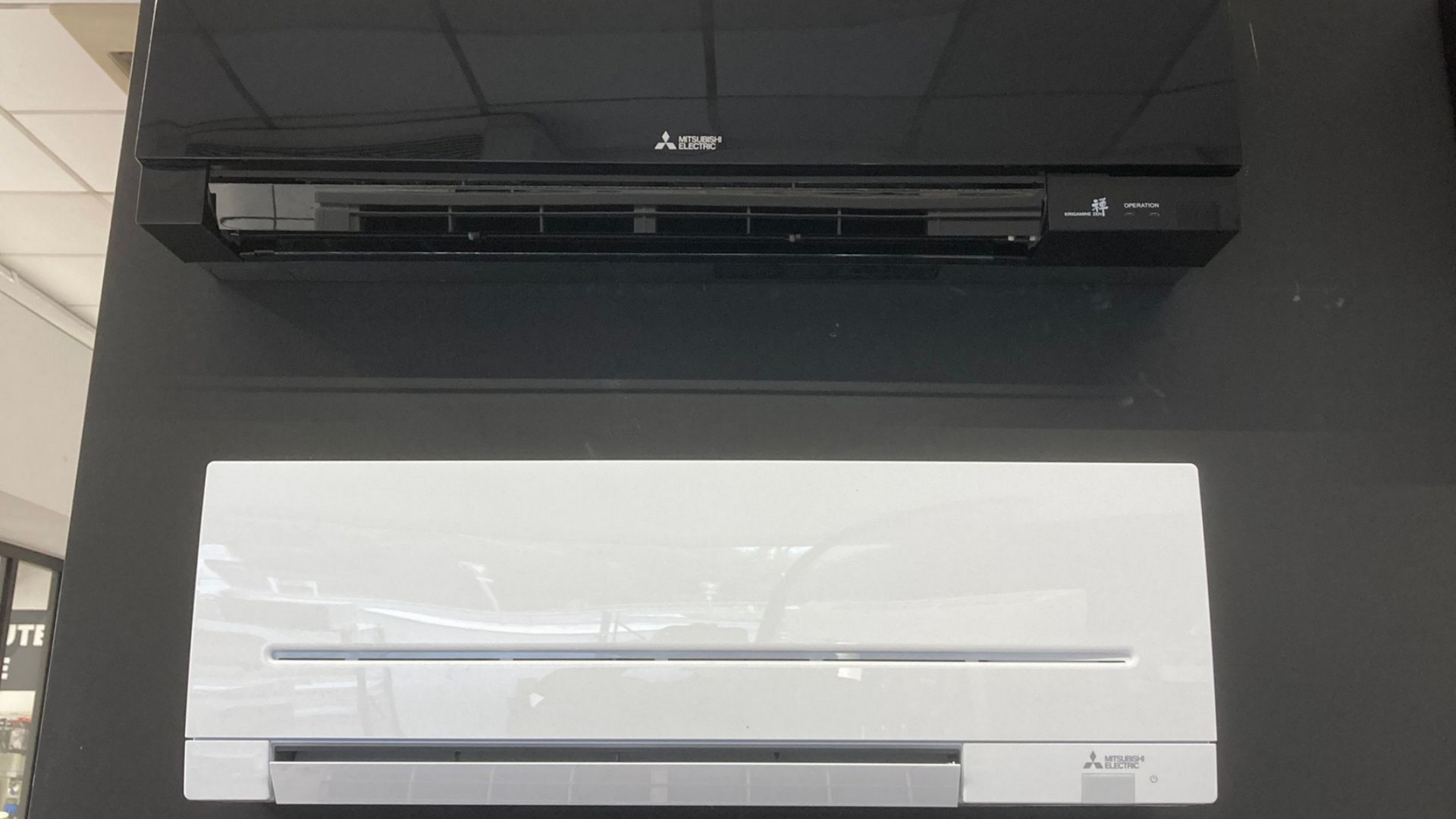 Chaudière murale blanche à côté d'un chauffe-eau bleu, reliés par des tuyaux isolés noirs.