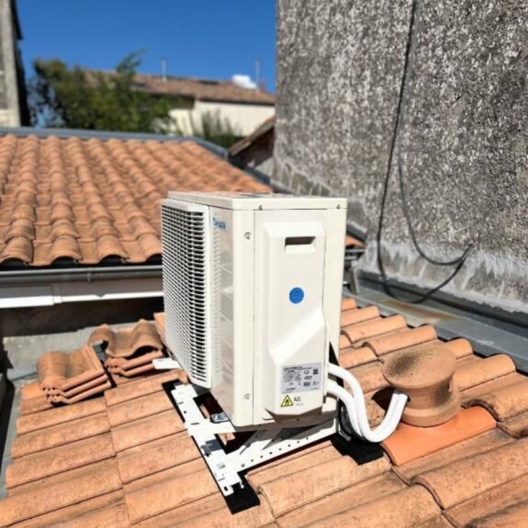 Quatre unités de climatisation sur le toit, installées sur une surface verte avec des passerelles métalliques.