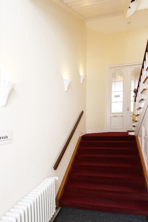 Ein Flur mit roten Teppichen ausgelegten Treppen und einem Heizkörper