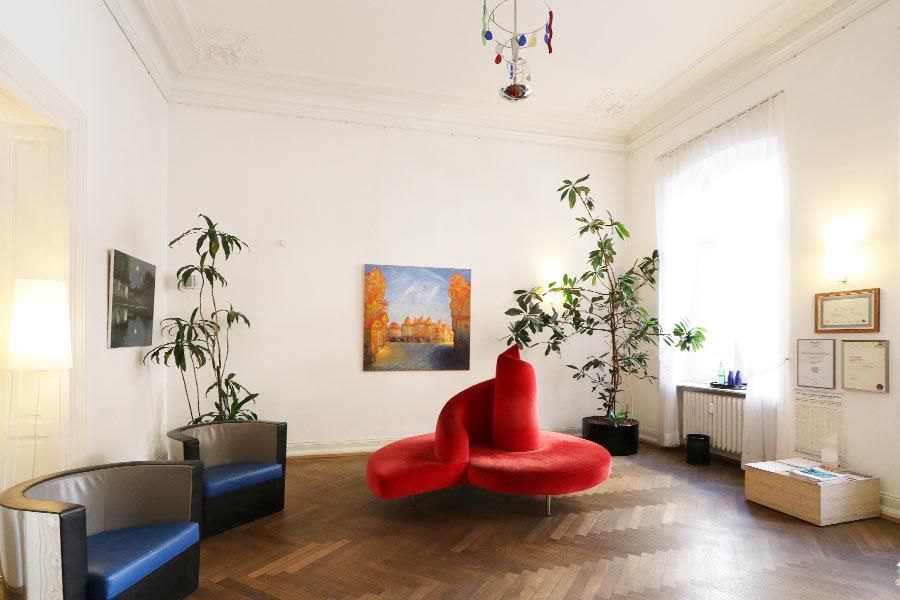 Ein Wohnzimmer mit einer roten Couch und zwei Stühlen