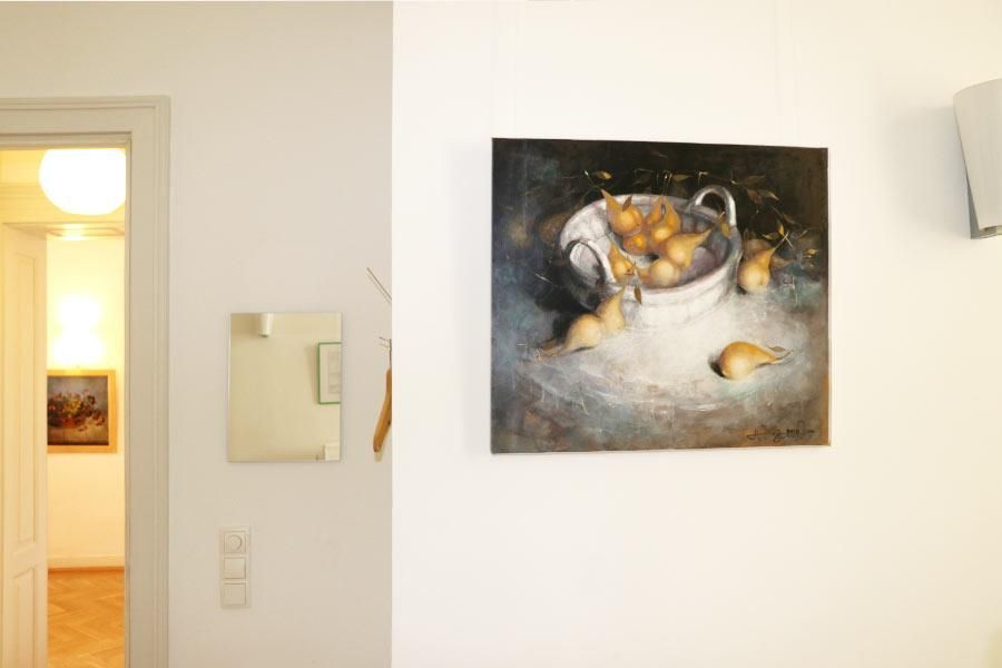 Ein Gemälde einer Schale mit Birnen hängt an einer weißen Wand