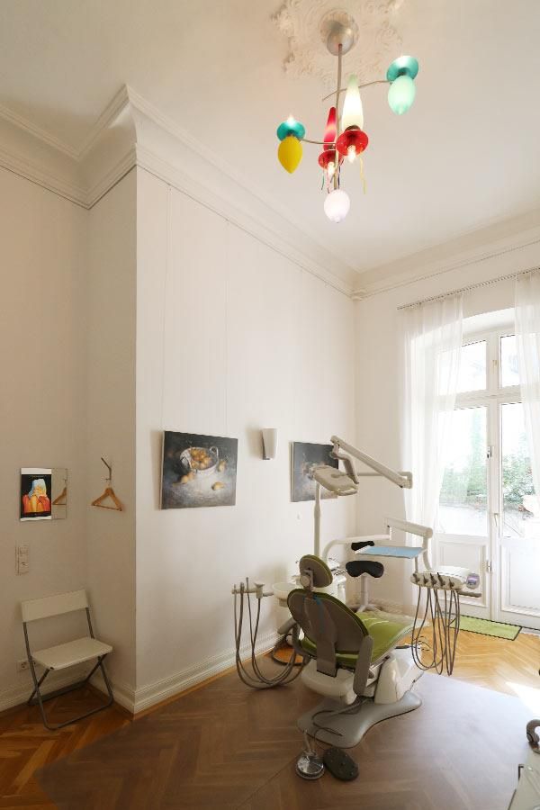 Ein Raum mit einem Zahnarztstuhl und einem Kronleuchter, der von der Decke hängt