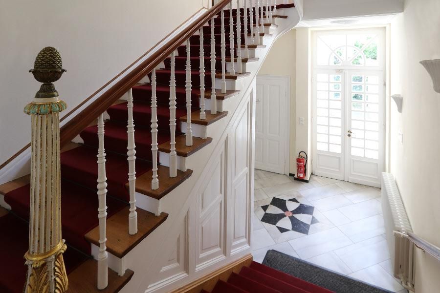 Eine Treppe mit einem roten Teppich und einem Feuerlöscher auf dem Boden