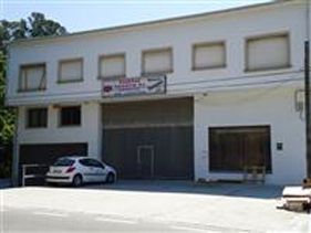 Un coche blanco está aparcado delante de un gran edificio blanco.