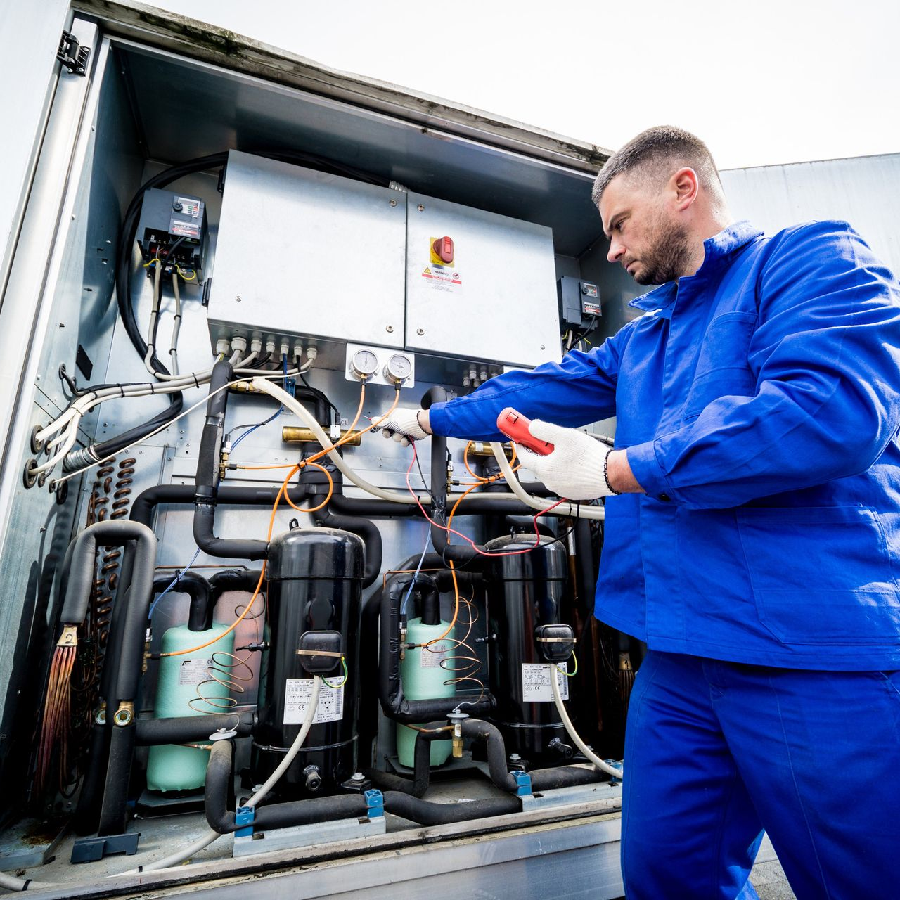 Conductos metálicos de aire acondicionado con rejillas y aislamiento, en exterior.