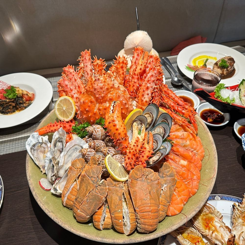 Una gran fuente redonda repleta de mariscos frescos, entre los que se incluyen cangrejo real, mejillones, gambas, ostras y langosta.