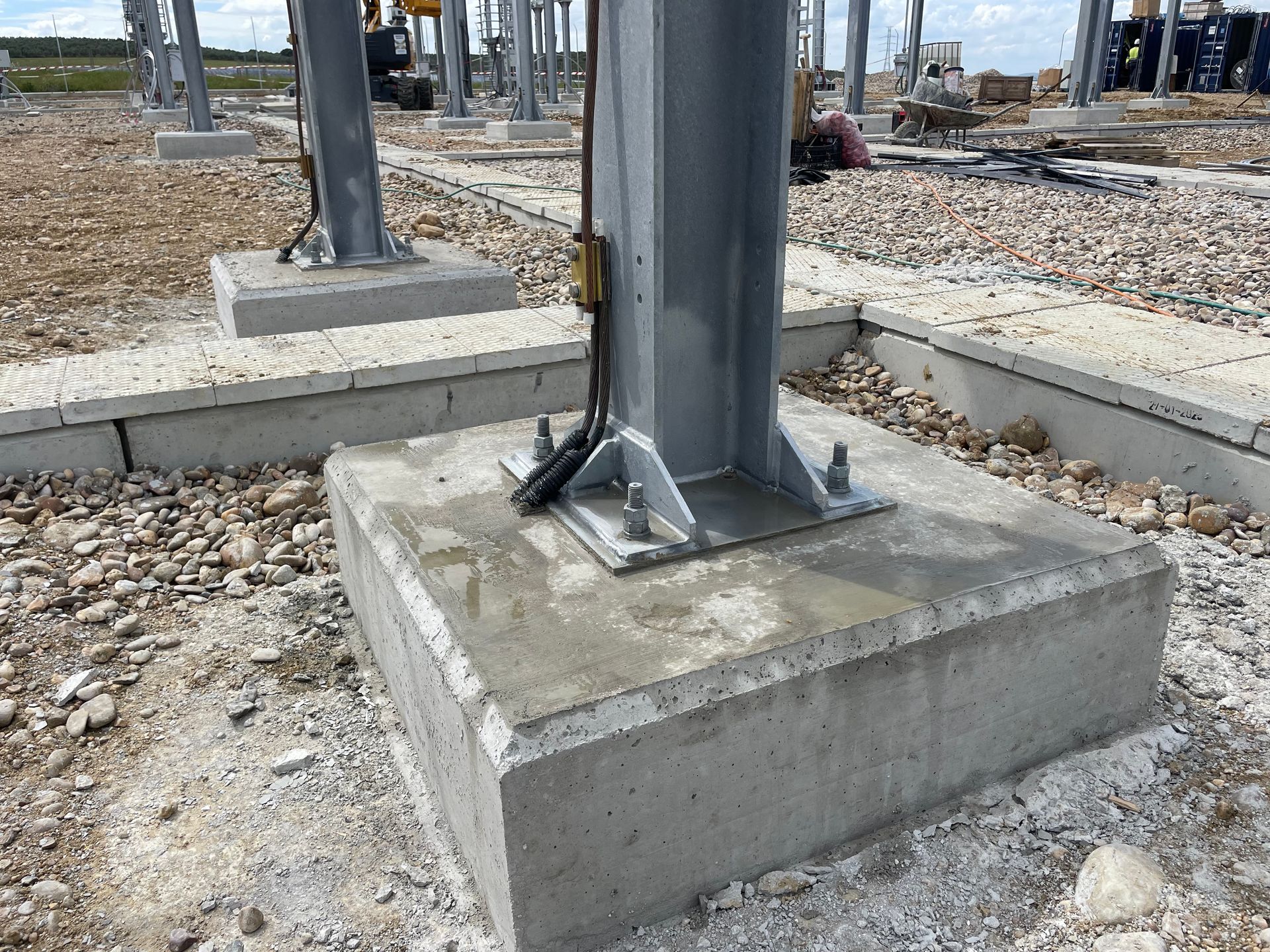 Base de hormigón con columna de acero atornillada a ella; obra en construcción.