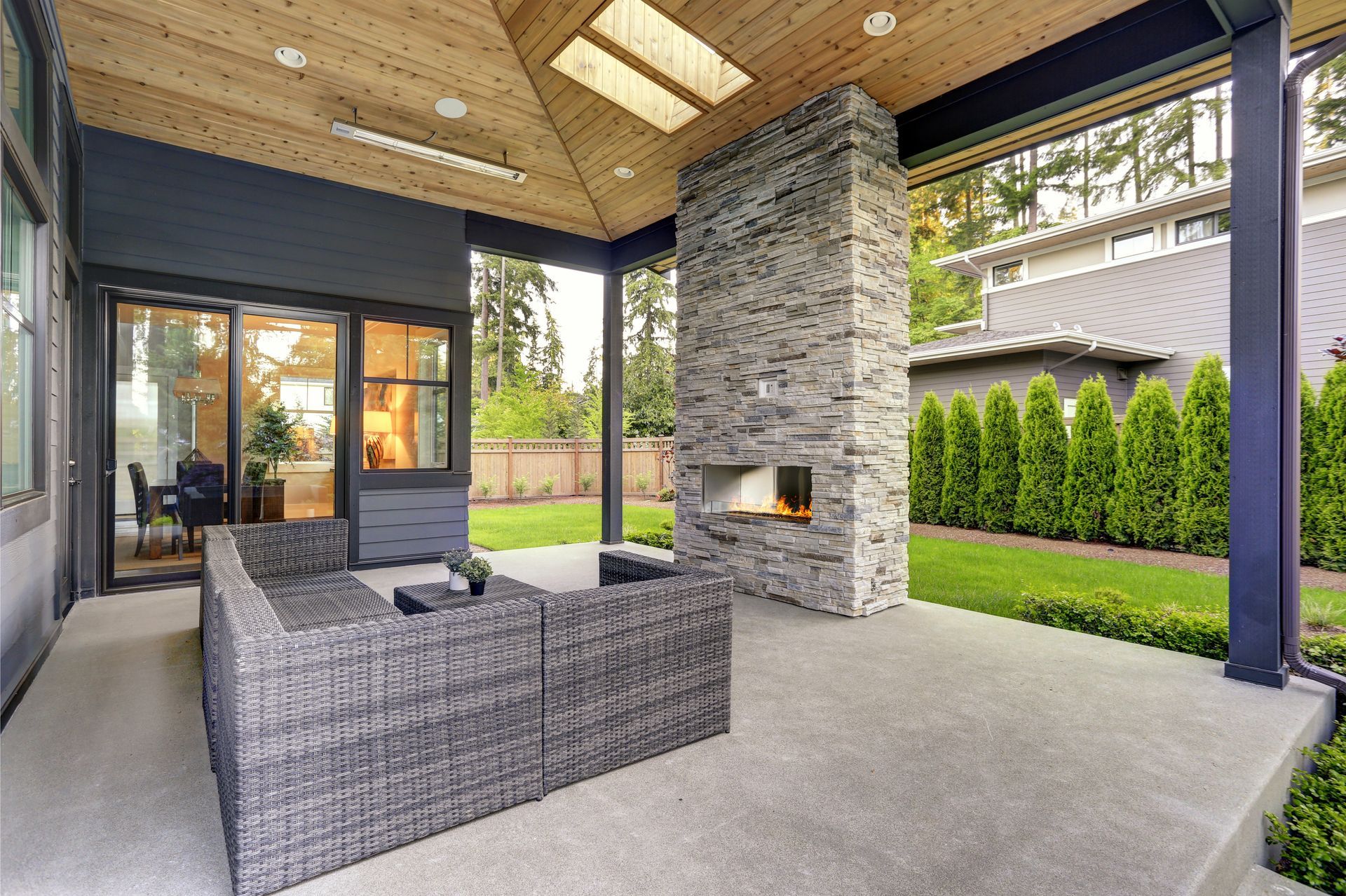 Une terrasse en béton avec un salon de jardin et une cheminée