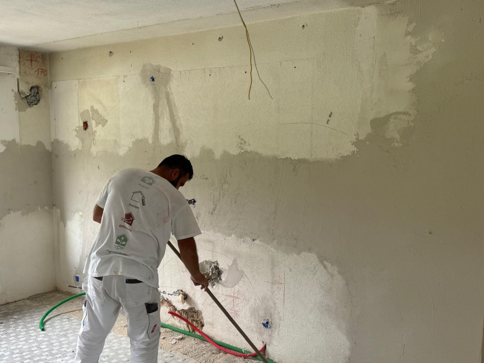 Zwei Männer stehen auf Gerüst und streichen Fassade